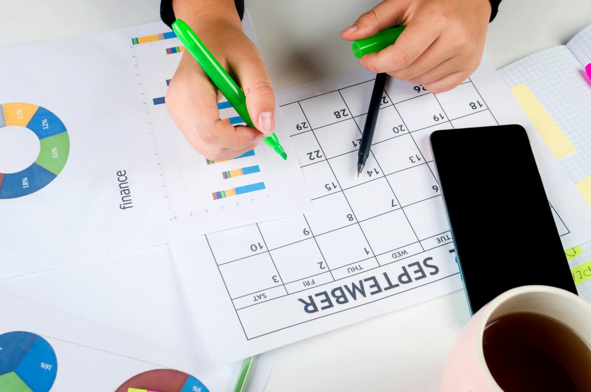 Girl Hands With Mobile Phone With Calendar Writing And List Of Work In Diary On Desk